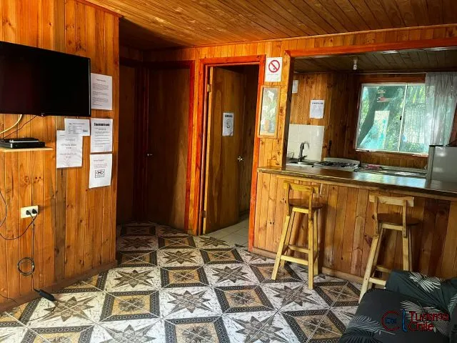 Vista interior del recinto con múltiples cabañas y grandes árboles