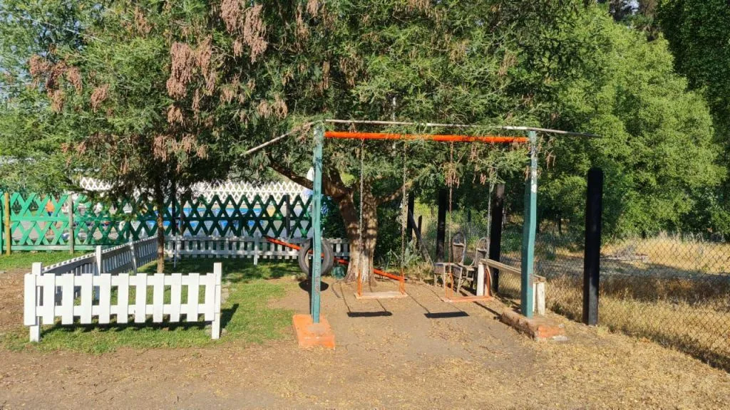 Bar tipo americano de madera con taburetes altos en cabaña